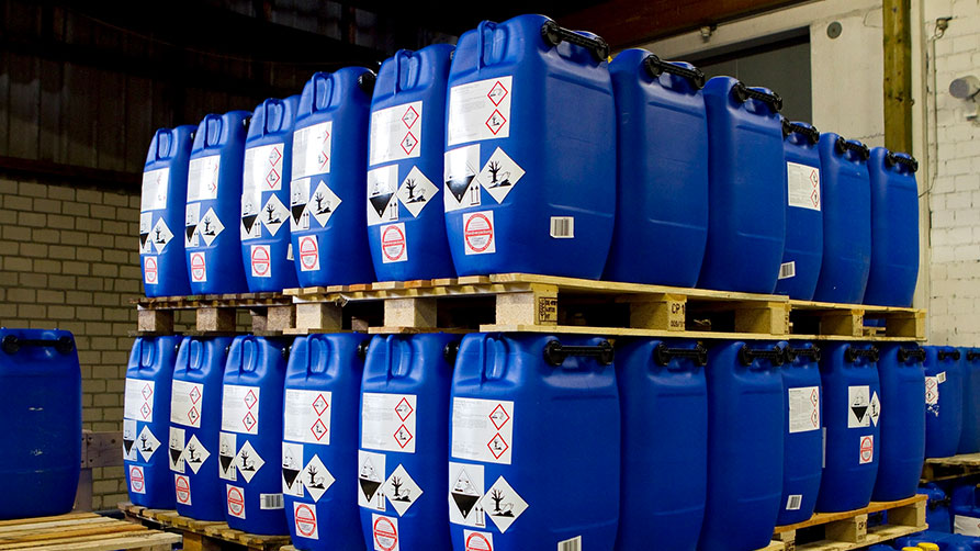 Gestapelte blaue Kunststoffkanister mit Gefahrstoffsymbolen Gestapelte blaue Kunststoffkanister mit Gefahrstoffsymbolen